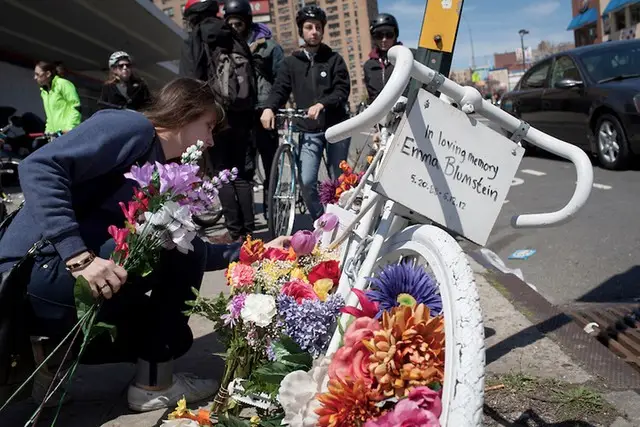 A mourner places flowers at a memorial for Emma Blumstein, a cyclist who was killed by a truck in Crown Heights last year. The truck driver was not charged with a crime